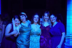 Five girls dressed for a party pose for the camera