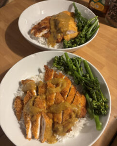 Two plates of homemade curry and broccoli