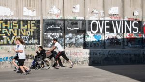 Palestine marathon runners by border wall
