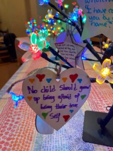 Flat heart-shaped decoration featuring the words "No child should group up feeling afraid of being their true self"