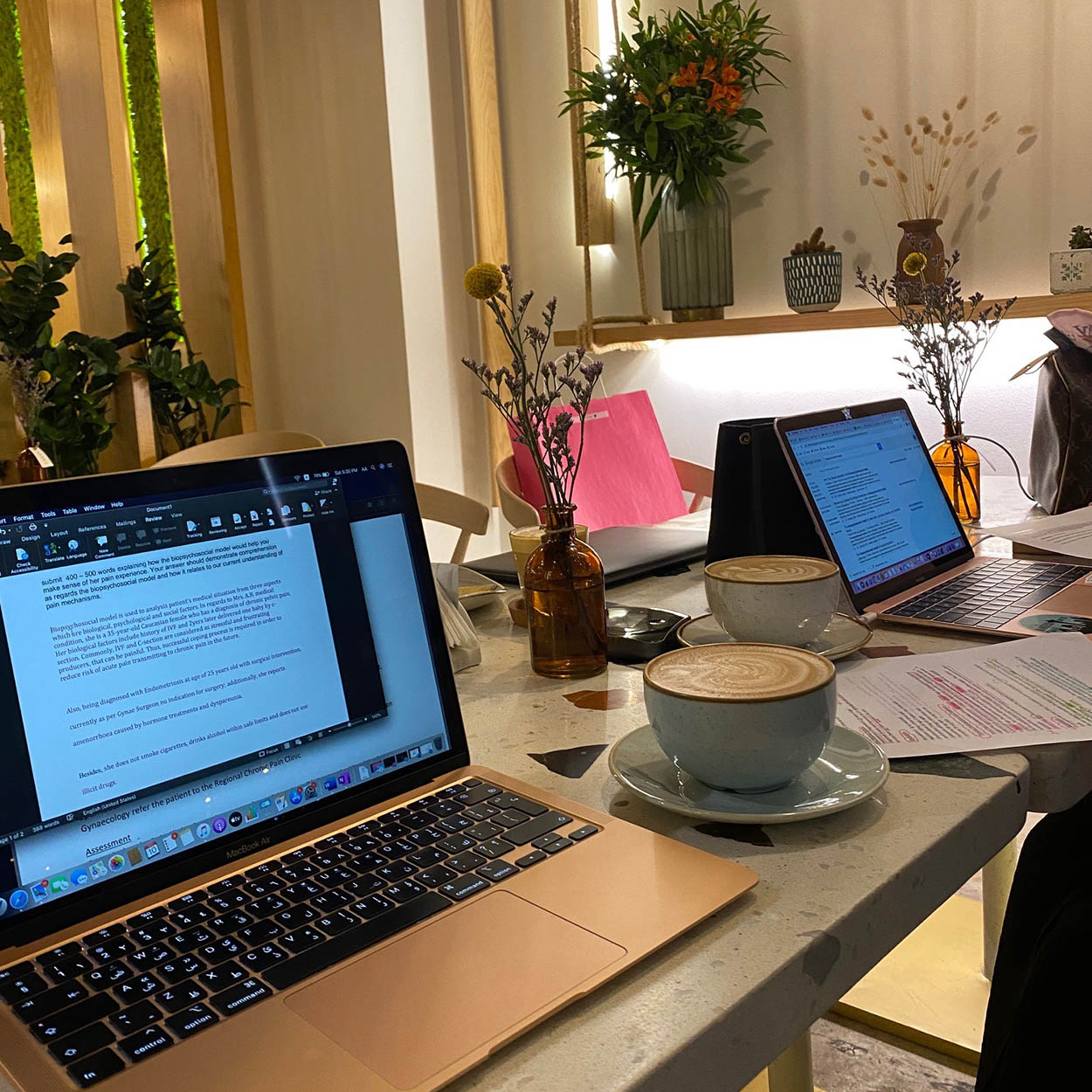 Image of two student's laptops at a cafe