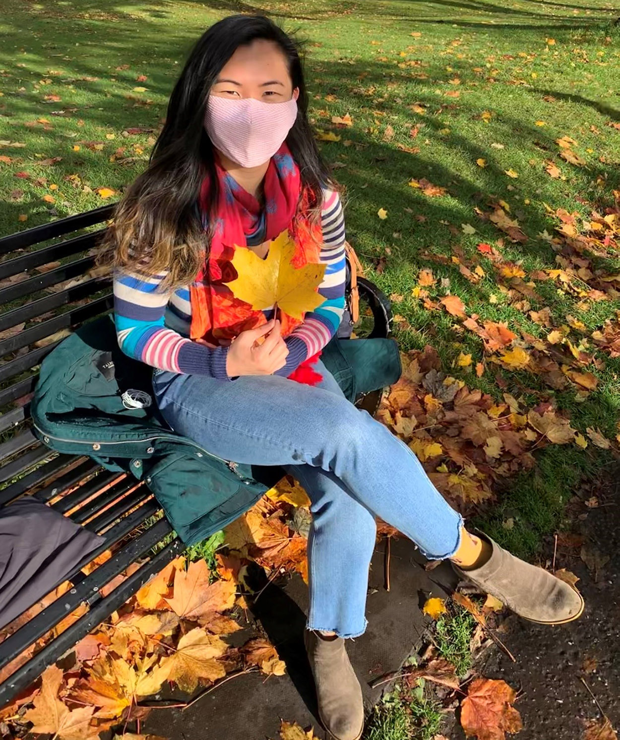 Emma sat on a bench wearing a mask