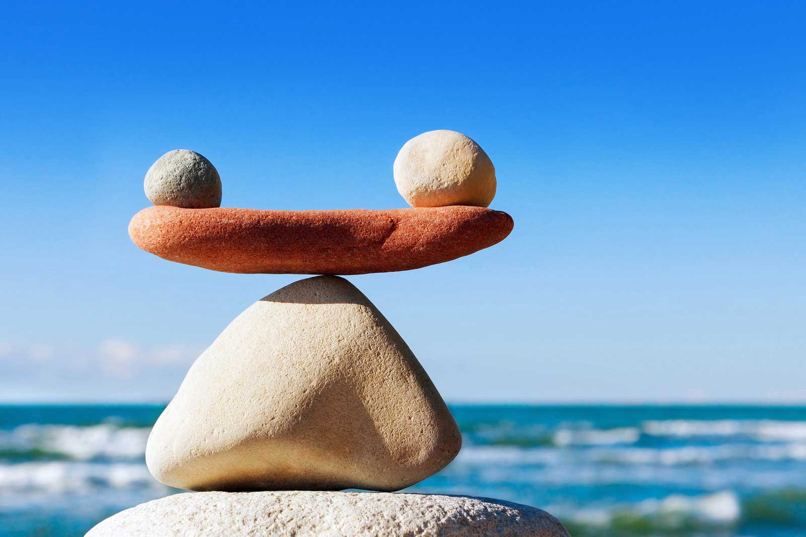 Image of stones balancing in front of the sea.