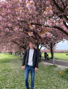 Student stood in front of Blossom trees