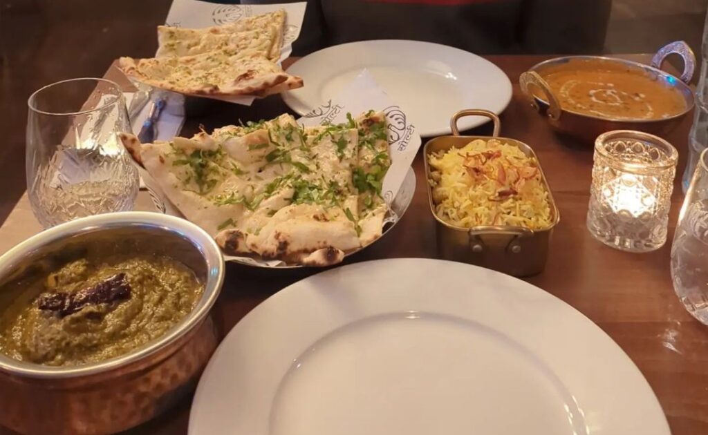 A restaurant table with naan bread and curry