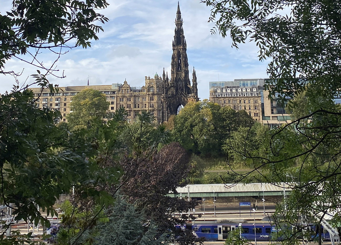 View of Princes Street. A train in the foreground and the Scott monument in the background.