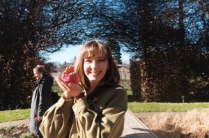A student posing with a toy outside.