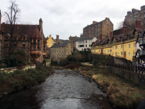 An array of different buildings by a river.