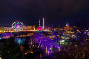 A skyline of Edinburgh at Christmas, with colourful lights from the attractions.