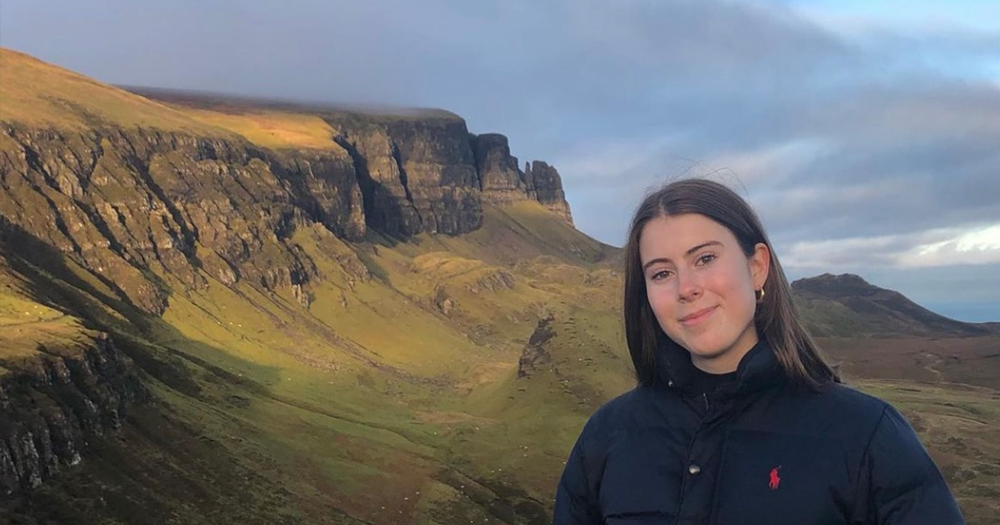 Student Eva stands in front of Scottish landscape