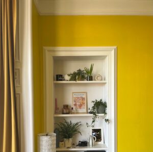 Recessed shelves with a yellow wall.