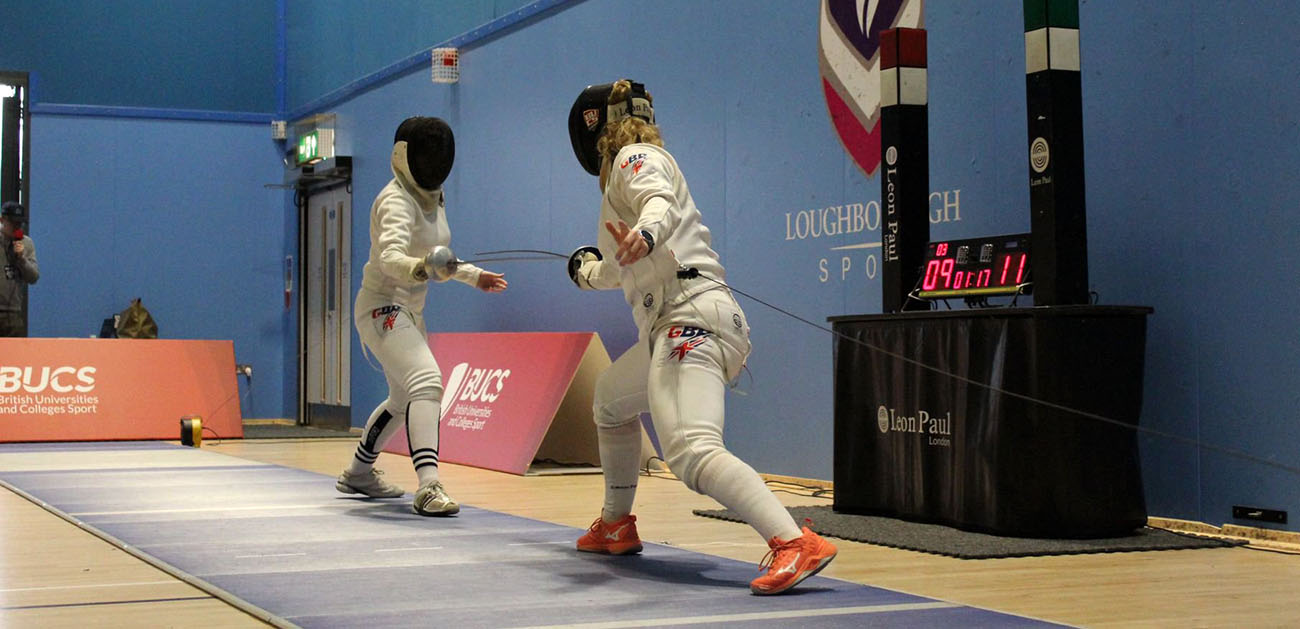 Two students fencing at a competition