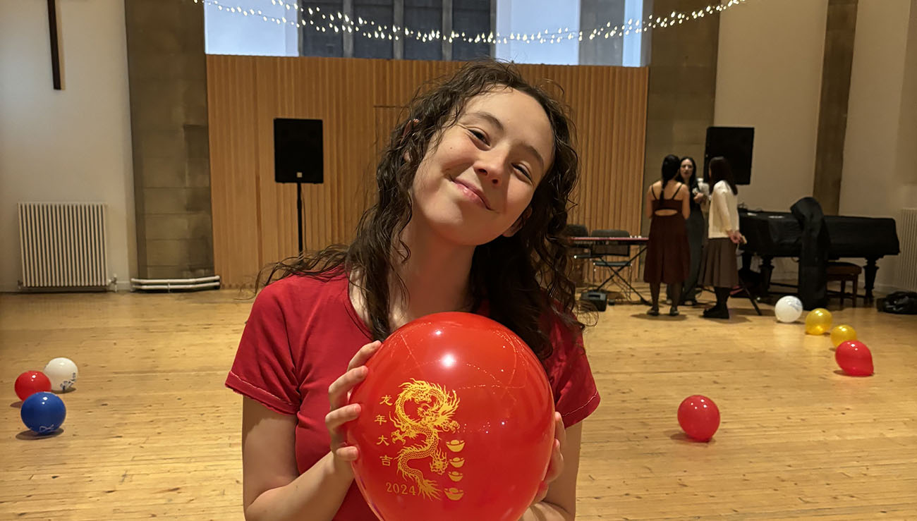 A student holding a red balloon