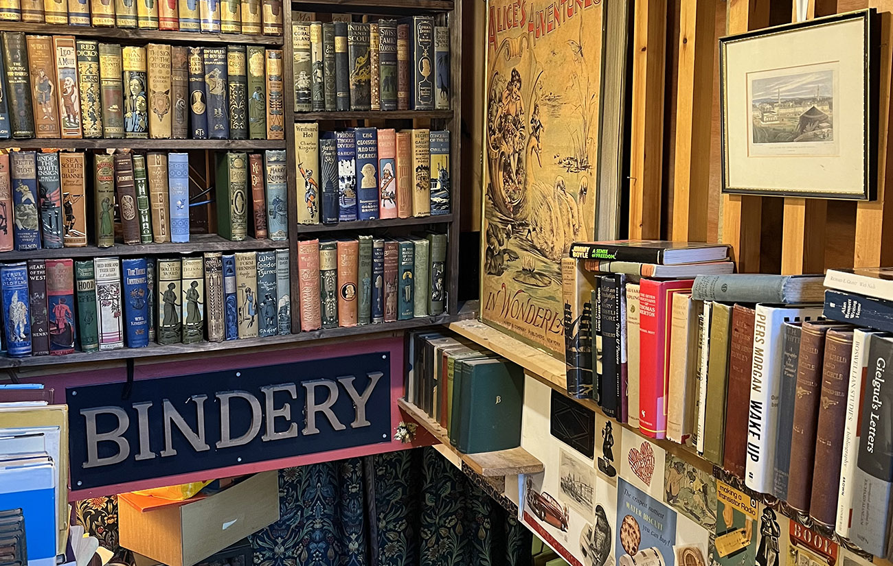 Book shelves and a sign that reads Bindery