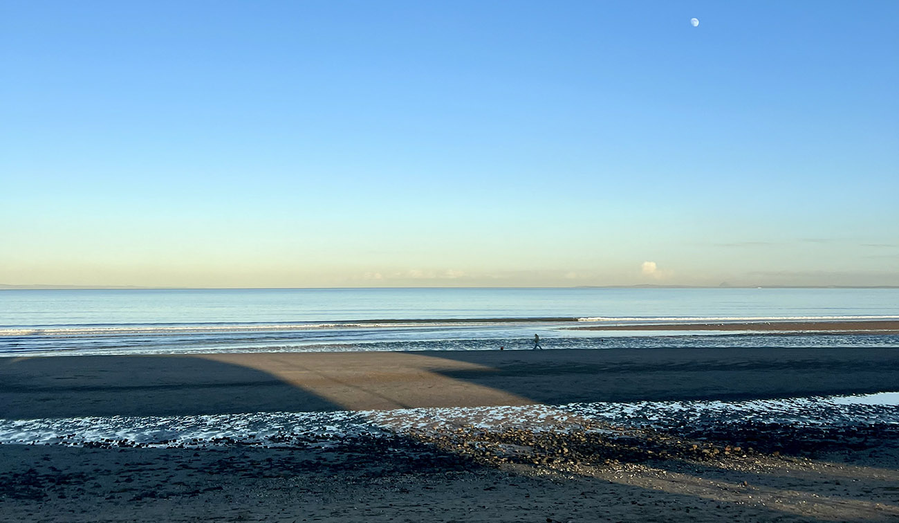 View of the beach and sea at sunset.