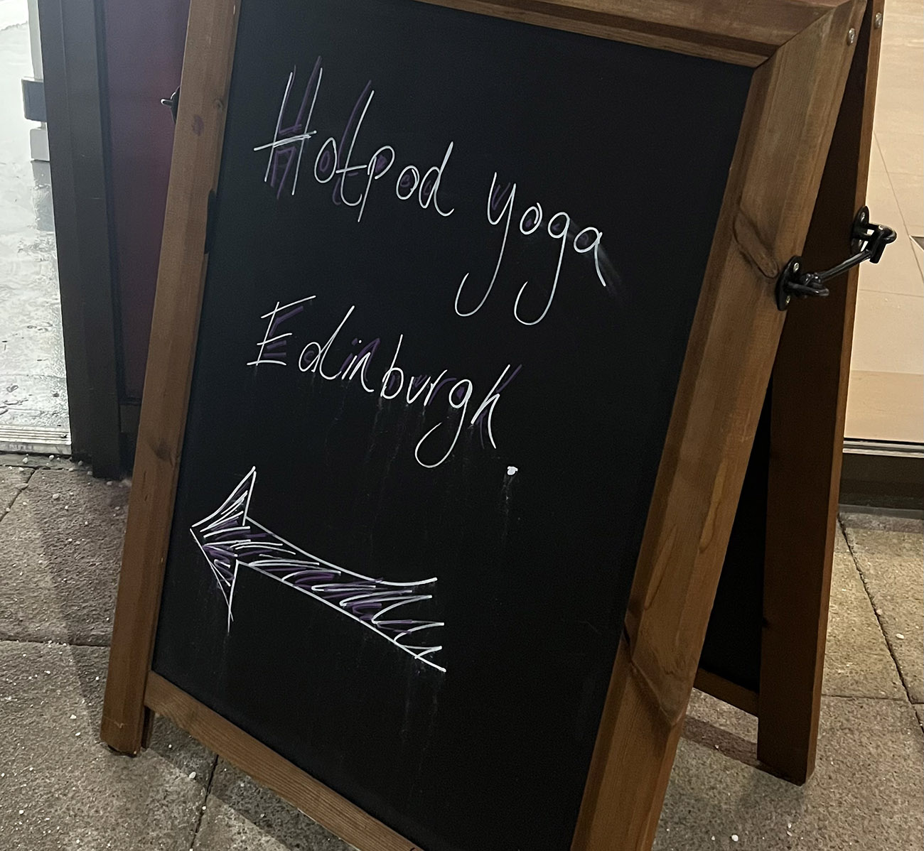 A chalk board stand with Hotpod Yoga Edinburgh written on it.