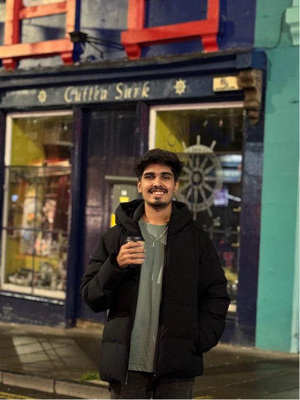 Smith walking in the evening on an Edinburgh street - holding a cup