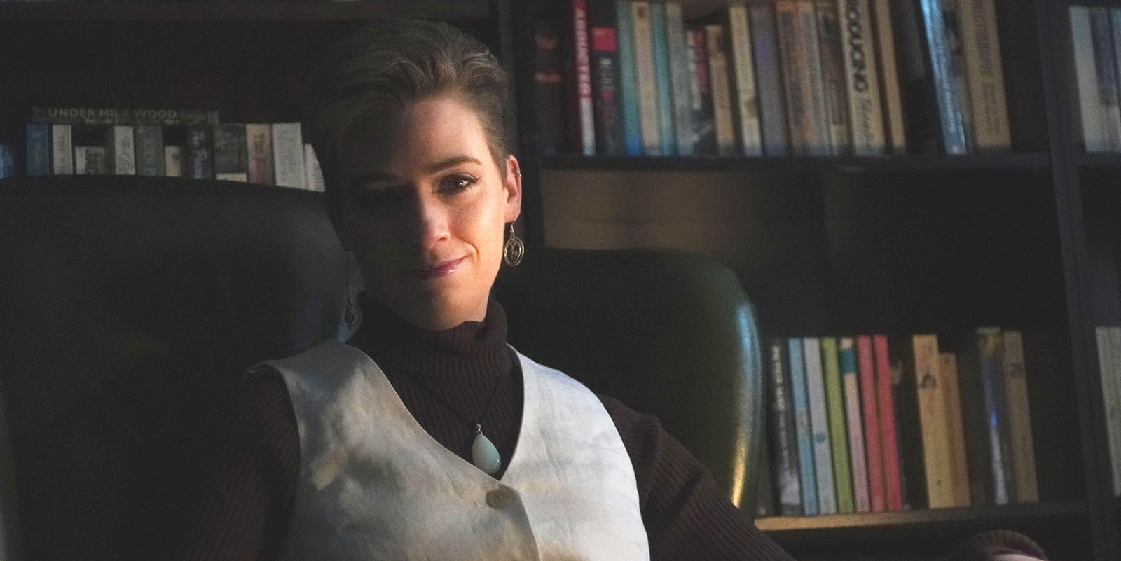 Molly sitting in front of bookshelves