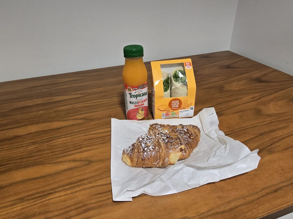 A drink, wrap and croissant on a table
