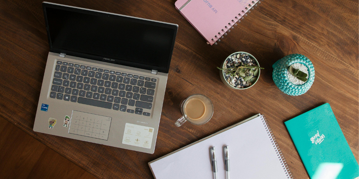 Laptop, coffee, and study materials on wooden table