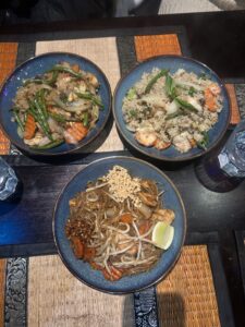 Three dishes containing rice or noodles.