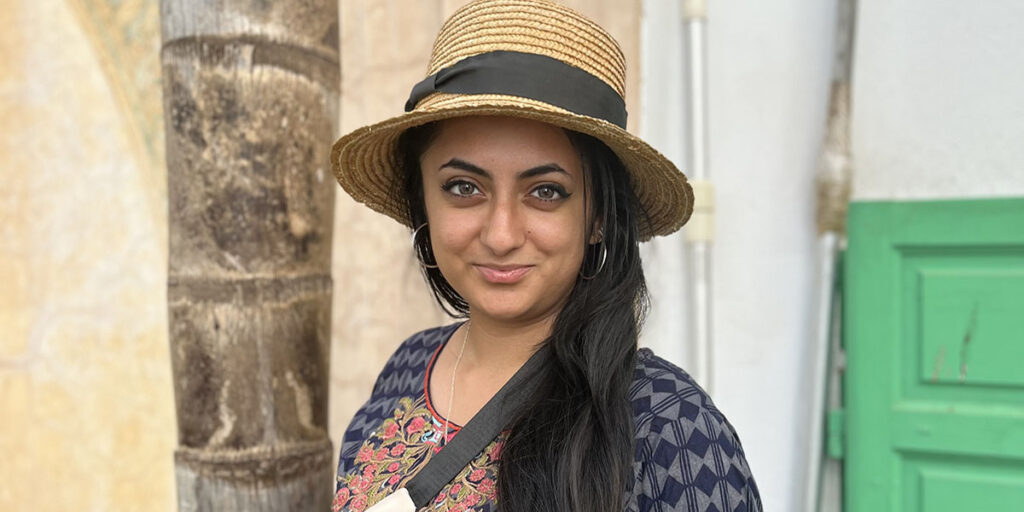 Muz wearing hat, travelling in a sunny location.