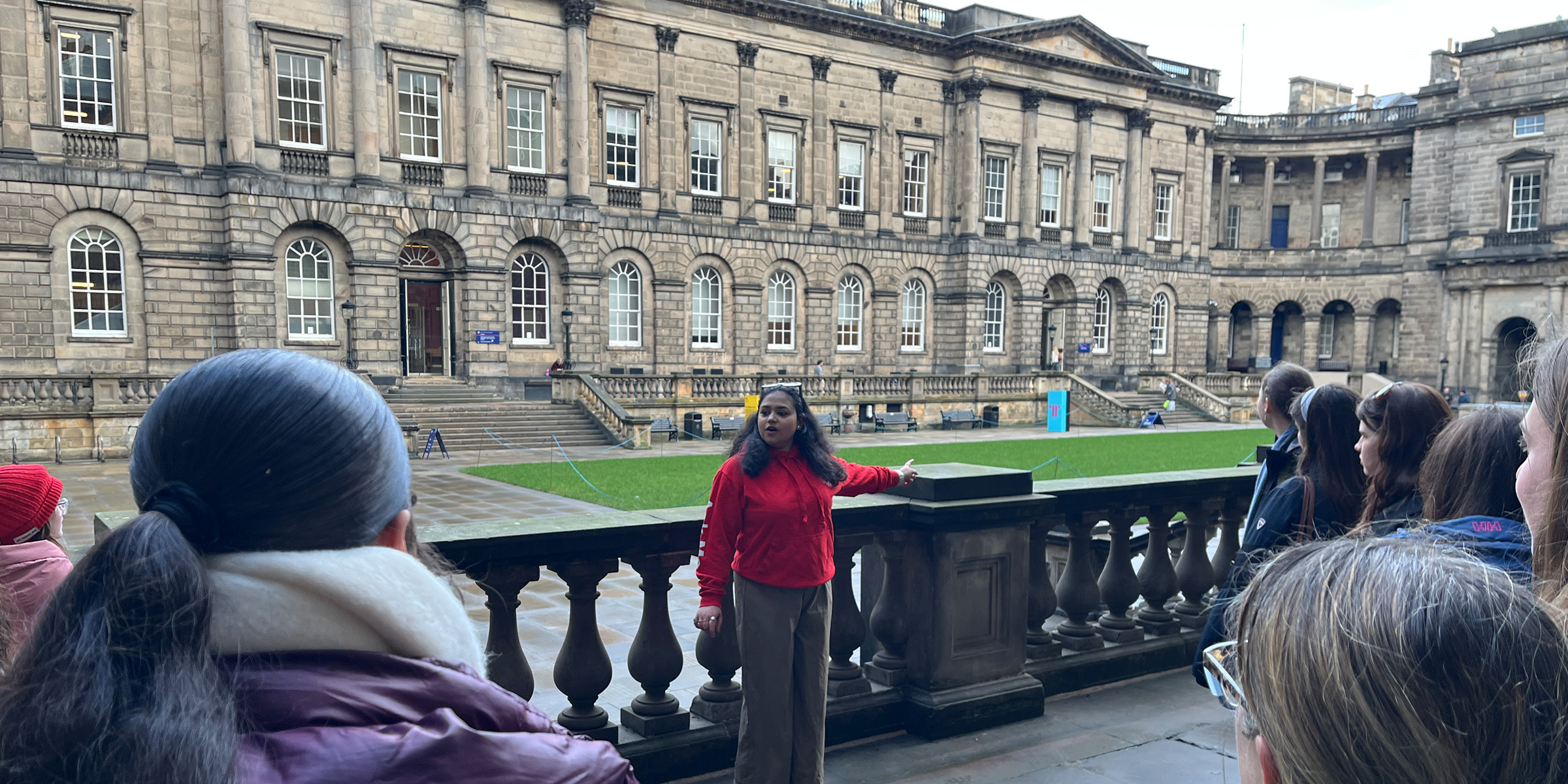 Student ambassador, Aagoon, leads a campus tour in the quad at Old College.