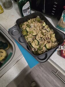 Food in a baking tray resting on top of another tray on a kitchen counter.