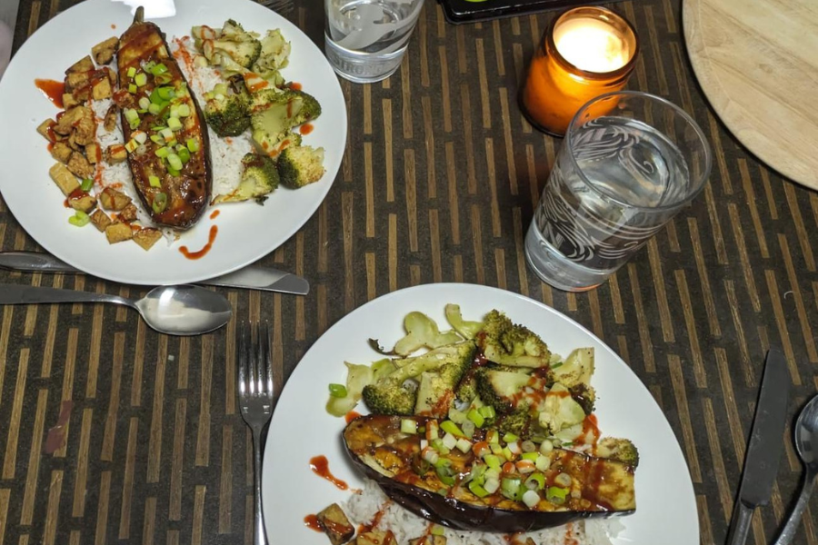Two plates of miso-aubergines with tofu and steamed broccoli.