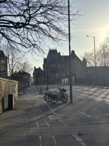 Two bikes parked on the pavement in Edinburgh. 