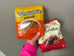 A hand holds up two packets of Polish snacks,