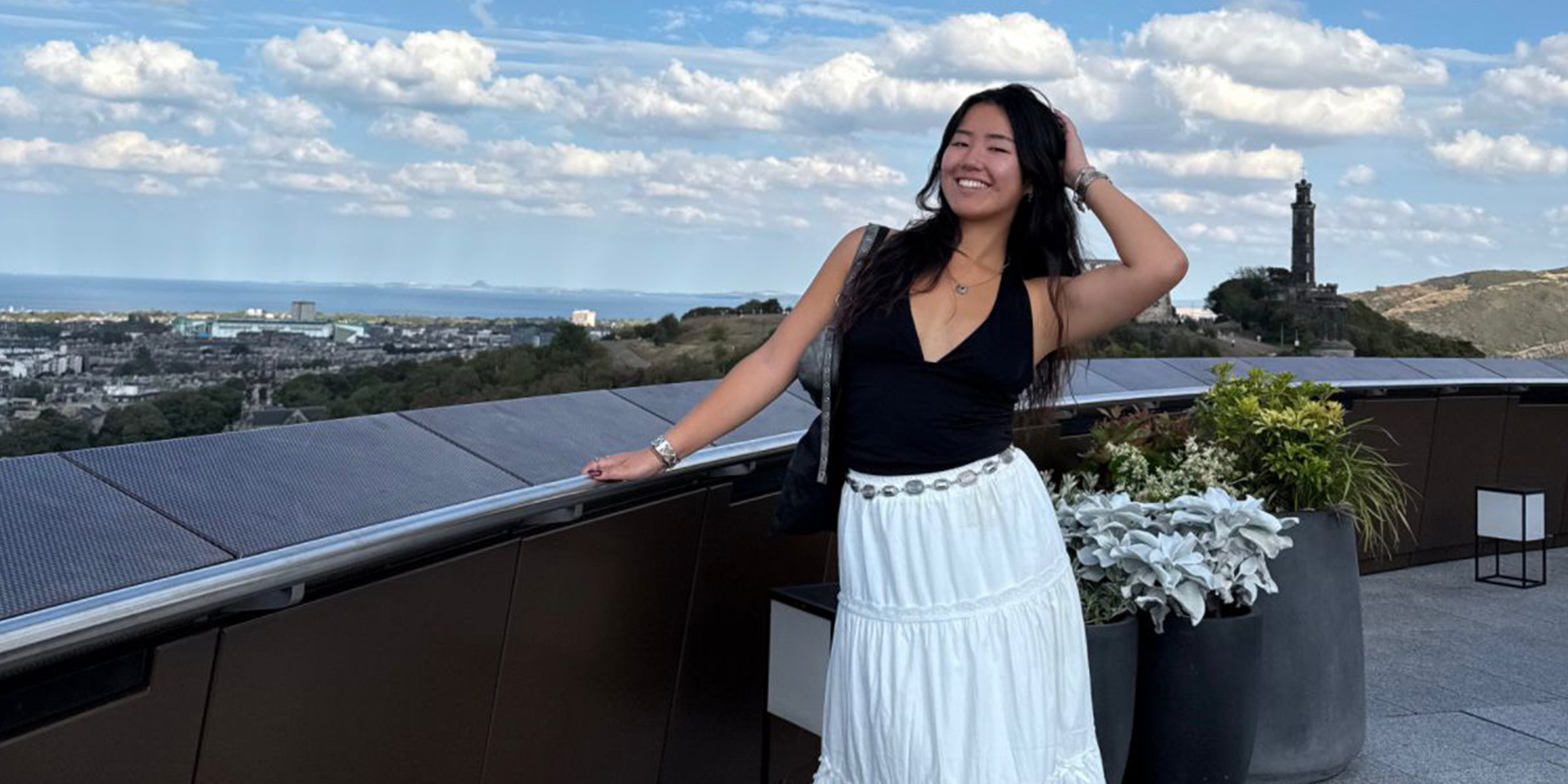 Student, Rowetta, smiles to camera an poses while stood in the roof terrace at the National Museum of Scotland.