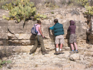 Geoscience students climbing in the desert on a field trip.