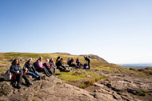 A group of people sitting on a hillside