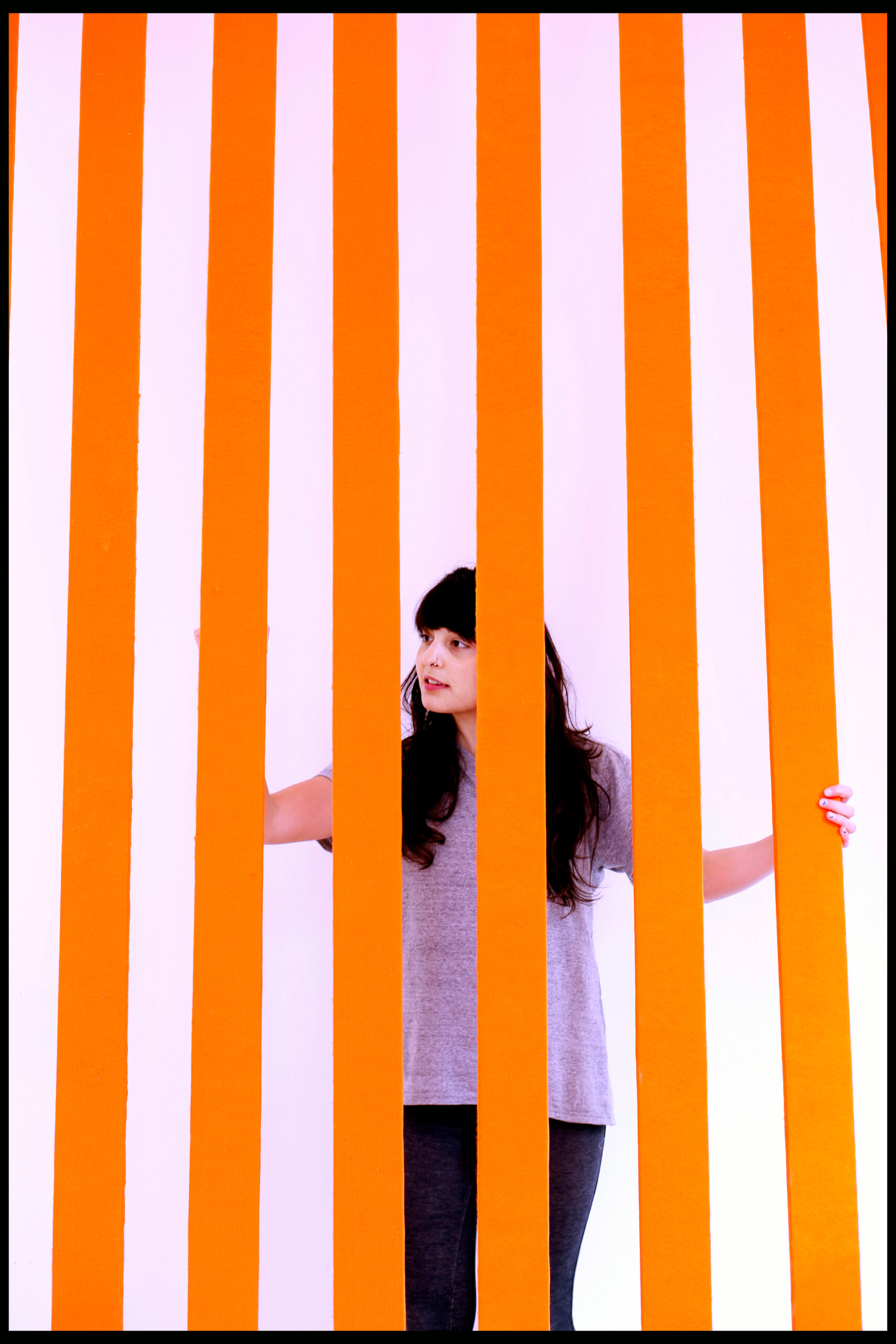 a student stands in front of a display of orange lines