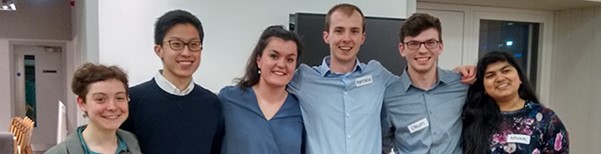 photograph of a group of medical students smiling at the camera with their arms around each other's shoulders. 