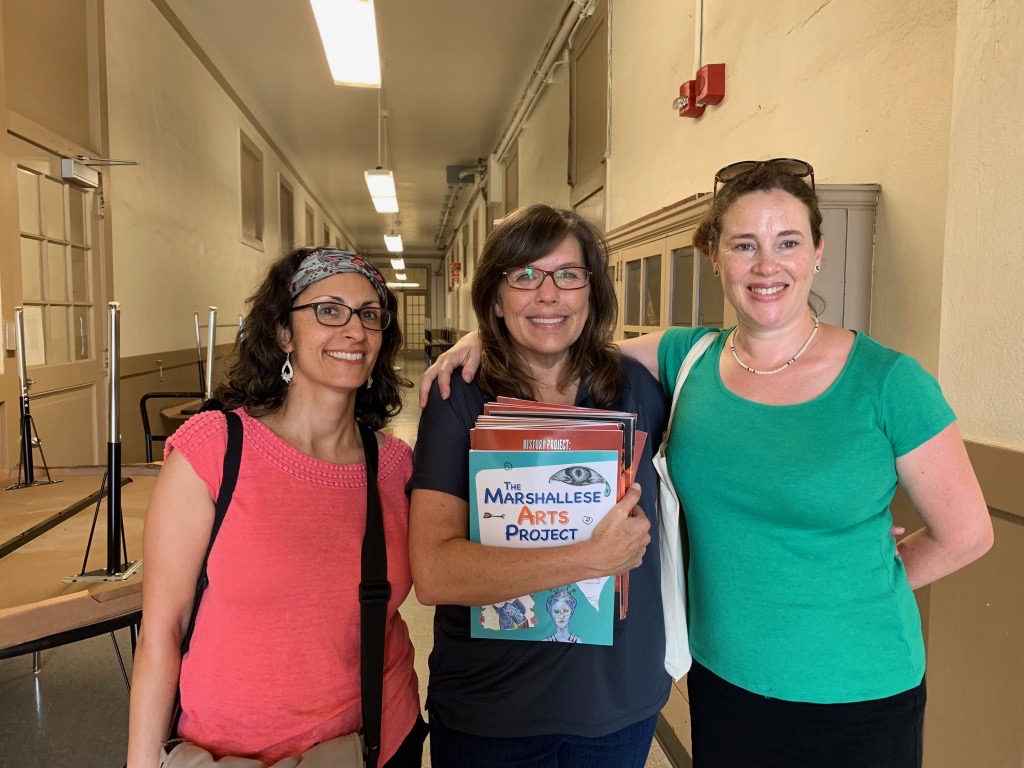 Picture of three women standing in a school hallway 