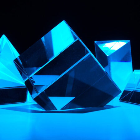 Prisms reflecting blue light on a black background