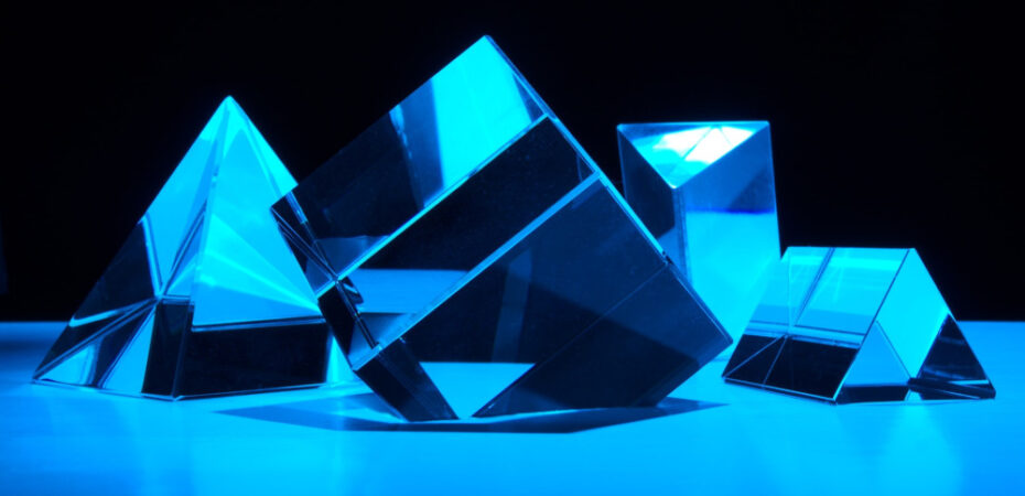 Prisms reflecting blue light on a black background