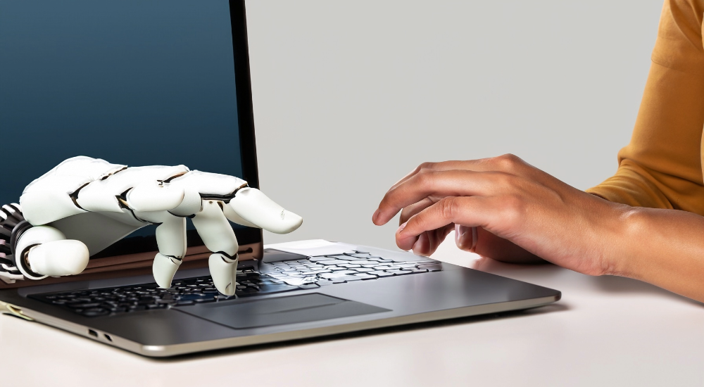 Laptop typing, one hand human and the other robot