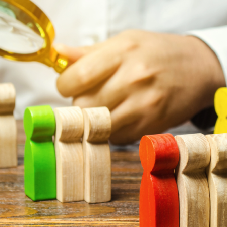 A photograph of a researcher in lab coat with a focus lens and shaped wooden blocks in blocks of three