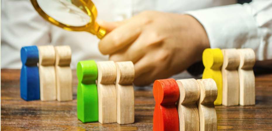 A photograph of a researcher in lab coat with a focus lens and shaped wooden blocks in blocks of three