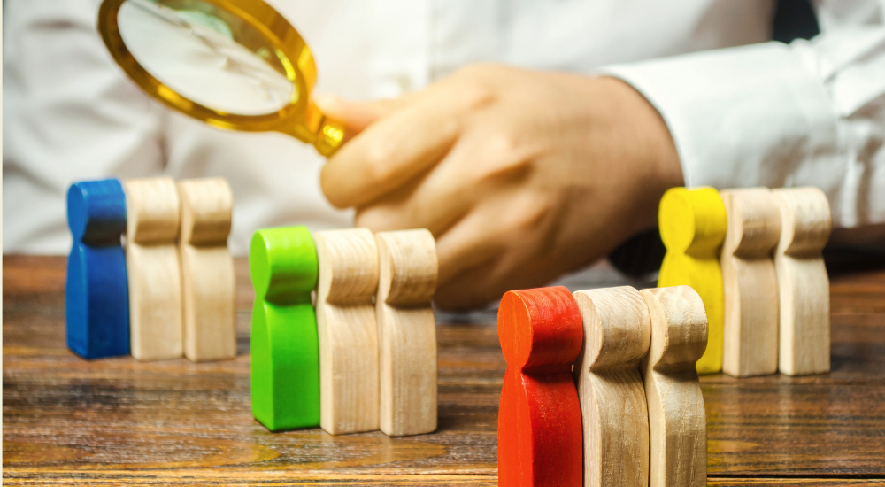 A photograph of a researcher in lab coat with a focus lens and shaped wooden blocks in blocks of three