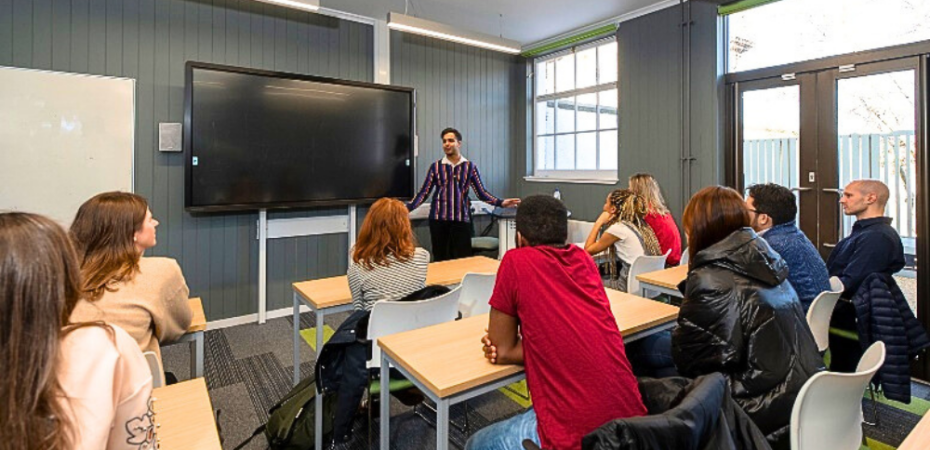 Photograph of students in a lecture hall and teacher giving a talk