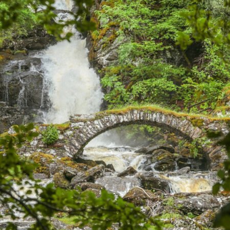 Bridge in Scotland with waterfall in background