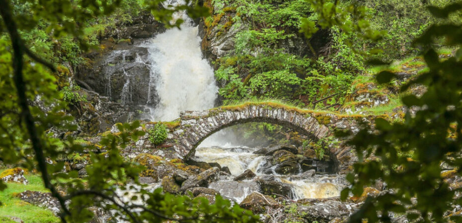 Bridge in Scotland with waterfall in background