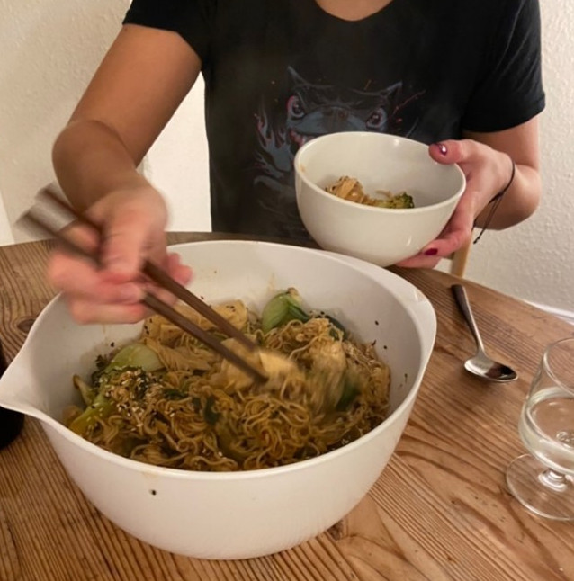 Photo of someone dishing up noodles into a bowl