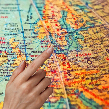 Hand pointing to countries on a globe