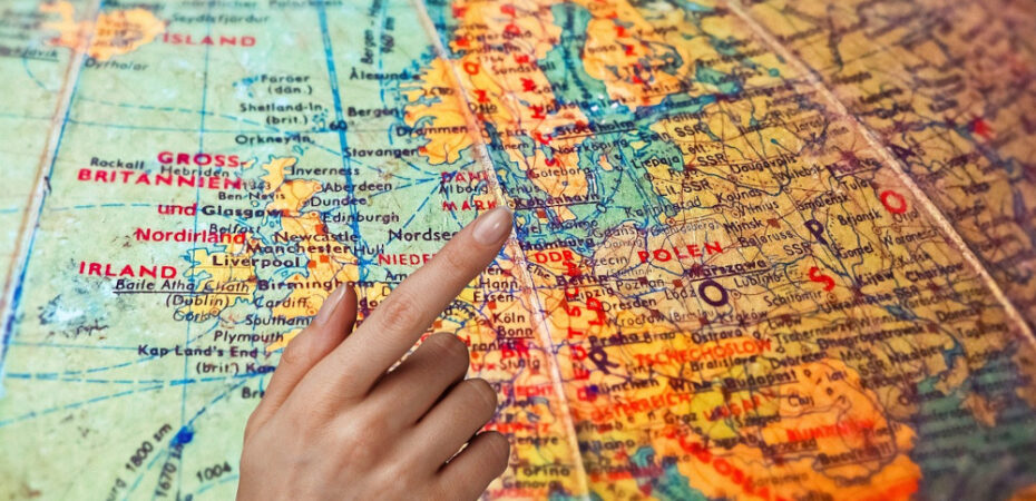 Hand pointing to countries on a globe