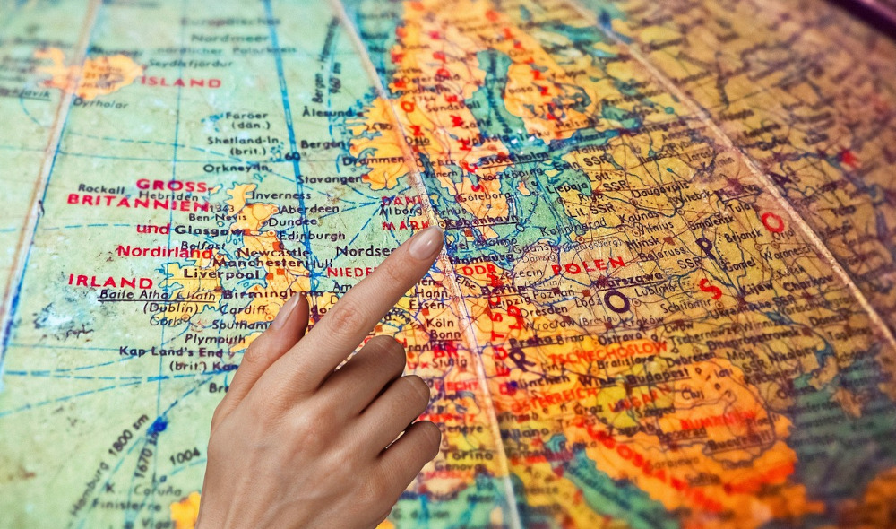 Hand pointing to countries on a globe